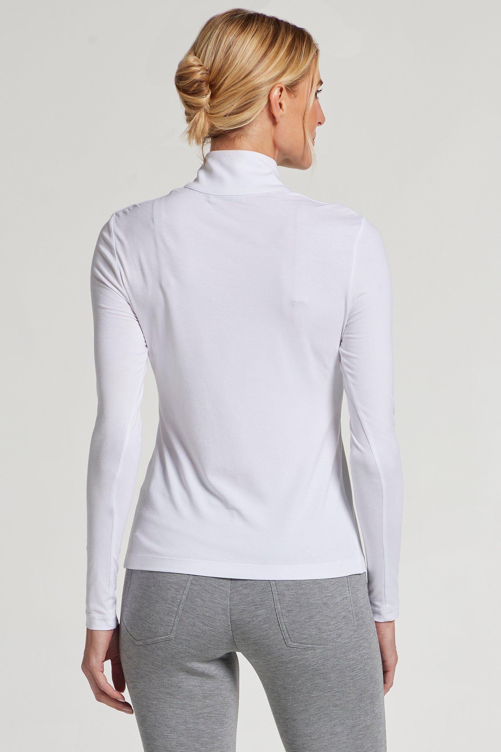 The Best Travel Top. Woman Showing the Back Profile of a Stacey Top in White.