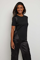 The Best Travel Top. Woman Showing the Side Profile of a Carmella Top in Black.