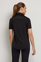 The Best Travel Top. Woman Showing the Back Profile of a Helia Top in Black.