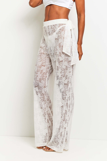 The Best Travel Pants. Woman Showing the Side Profile of a Moana Camo Mesh Pant in White.