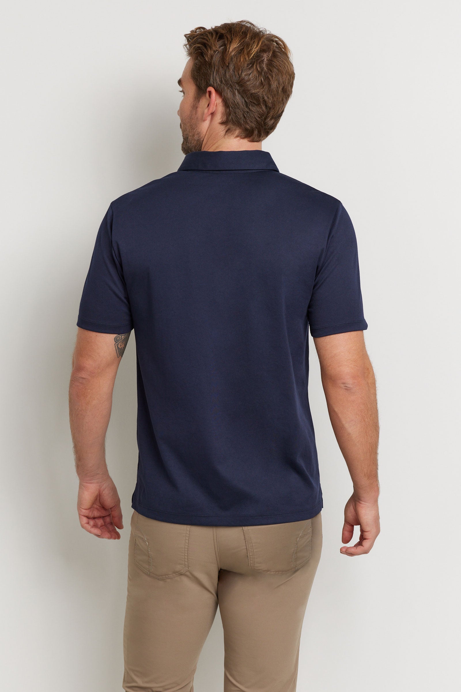 The Best Travel Top. Man Showing the Back Profile of a Men's Ryan Polo in Navy.