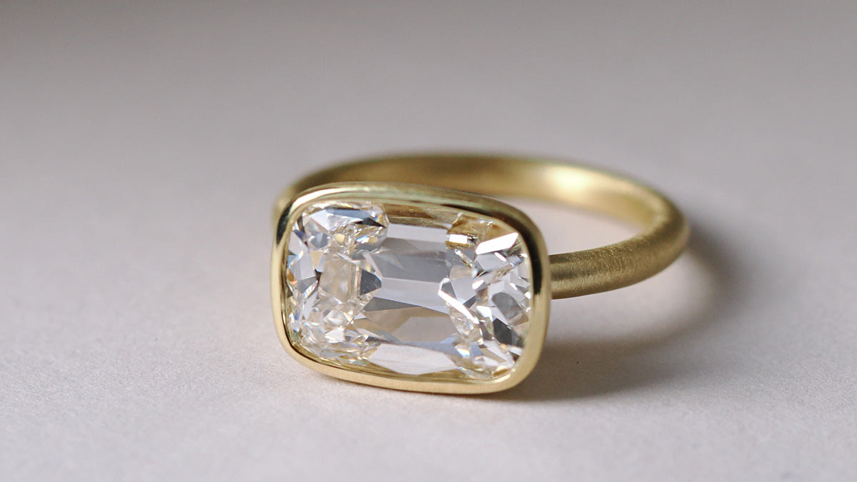 East West Old Mine cut diamond in a satin yellow gold bezel