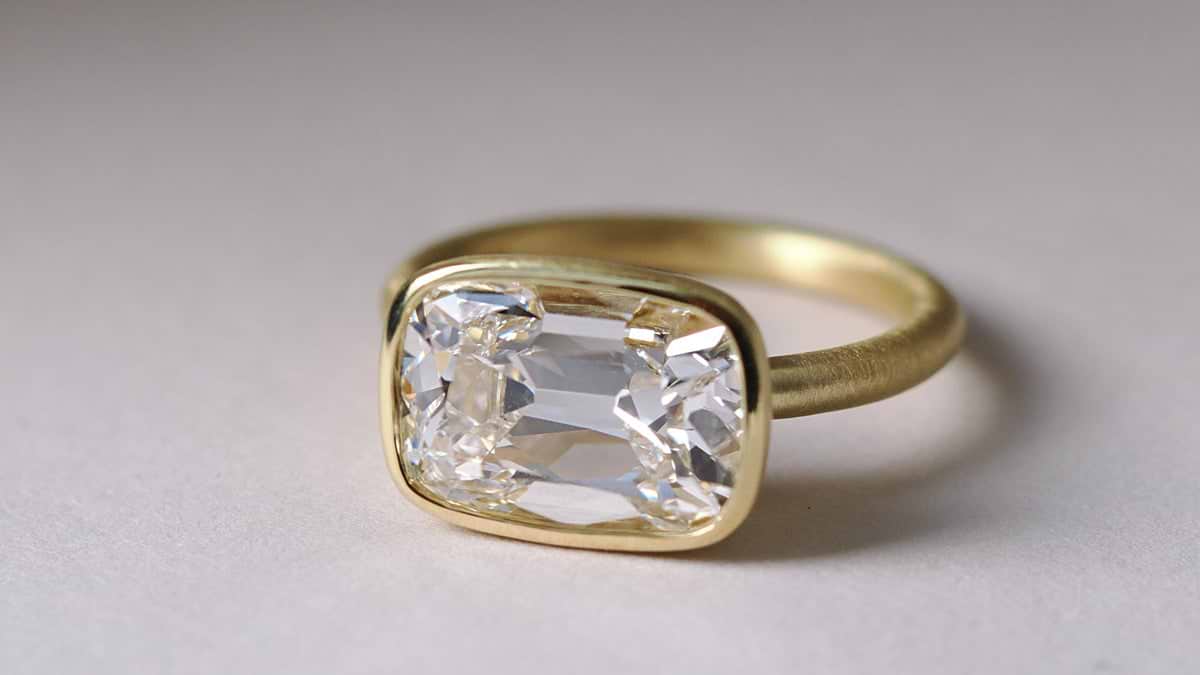East West Old Mine cut diamond in a satin yellow gold bezel