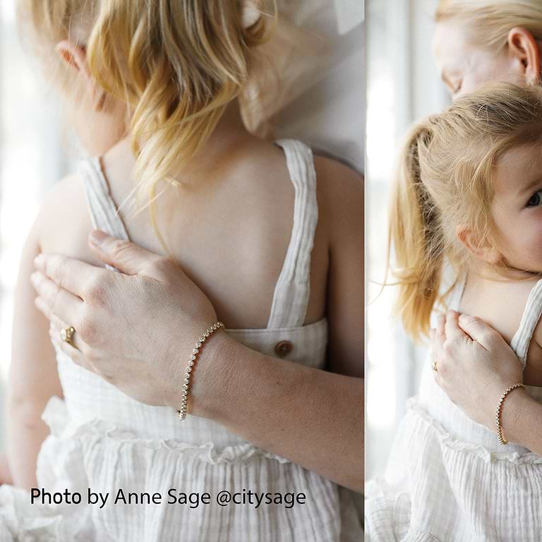 woman wearing an Anne Sage x Plum Diamonds perfect tennis bracelet holding her daughter