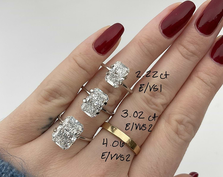 women's hand showing three different carat diamond rings