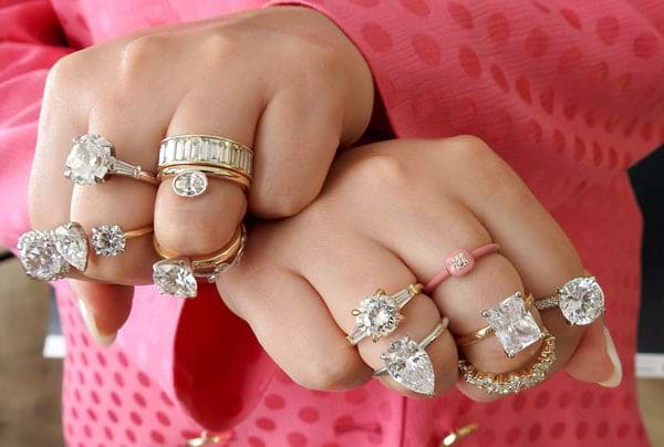 women's hand with several different style diamond rings