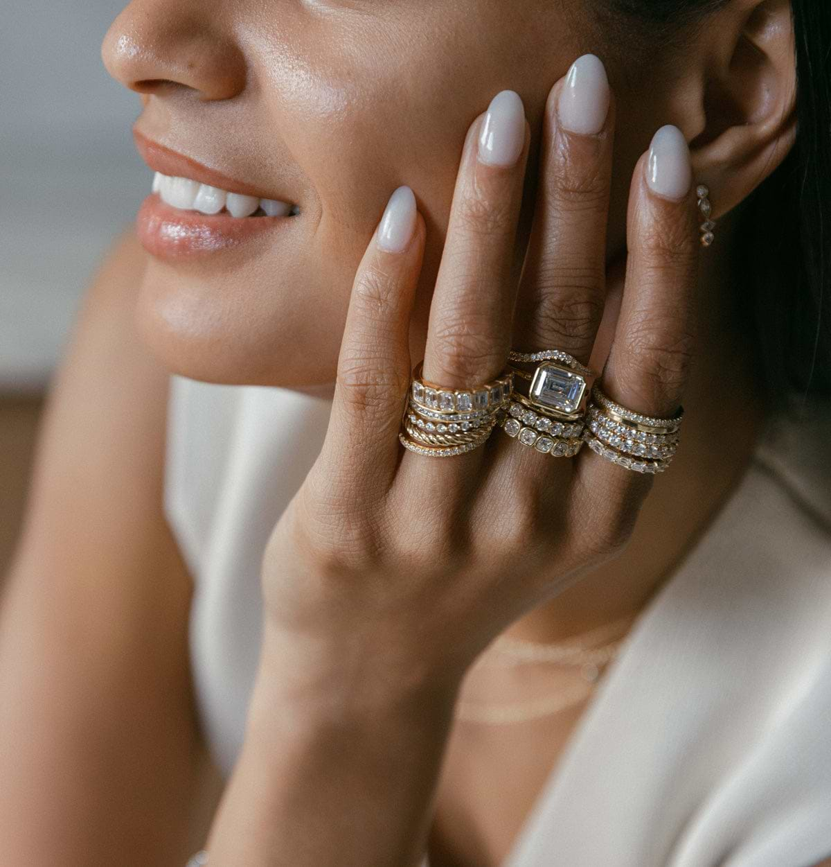 Hand stacked with yellow gold rings on fingers