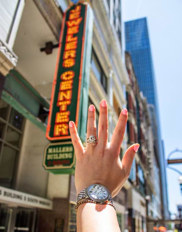 Hand with rings in front of marquee sign 