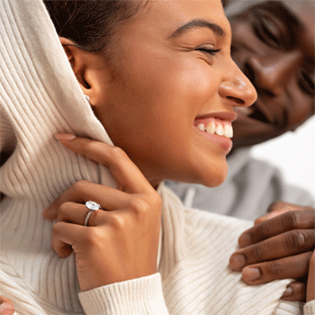 smiling woman wearing an engagement ring with her fiance