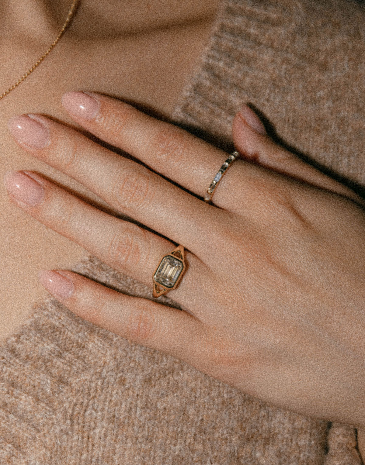 East west emerald split shank yellow gold ring on hand 