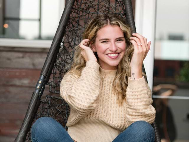 smiling woman wearing a yellow sweater