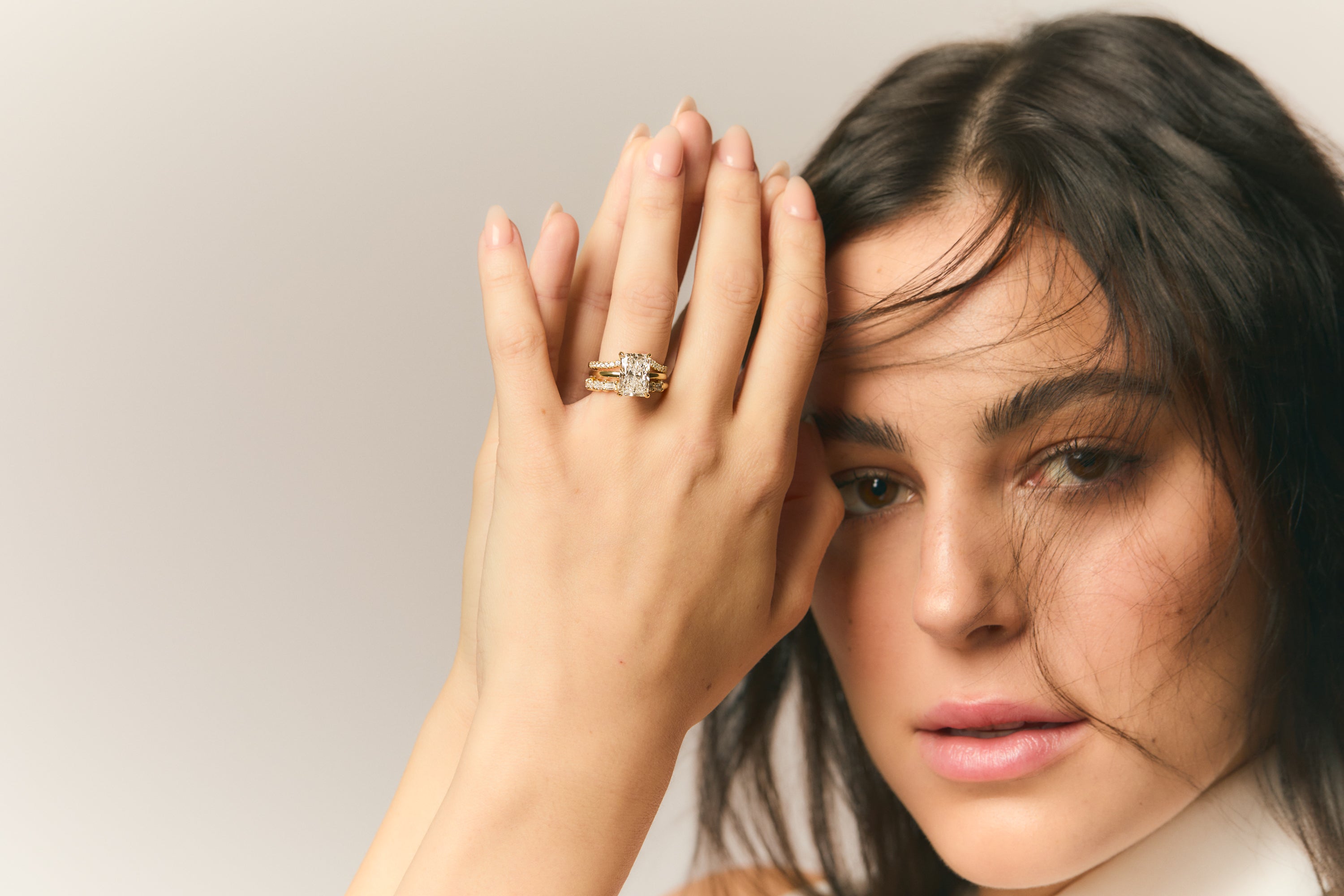 brunette woman with gold and diamond rings and fine jewelry