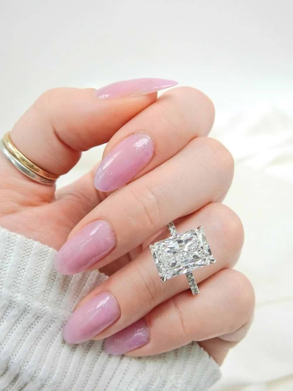 large radiant cut diamond ring with pave band on a woman's hand