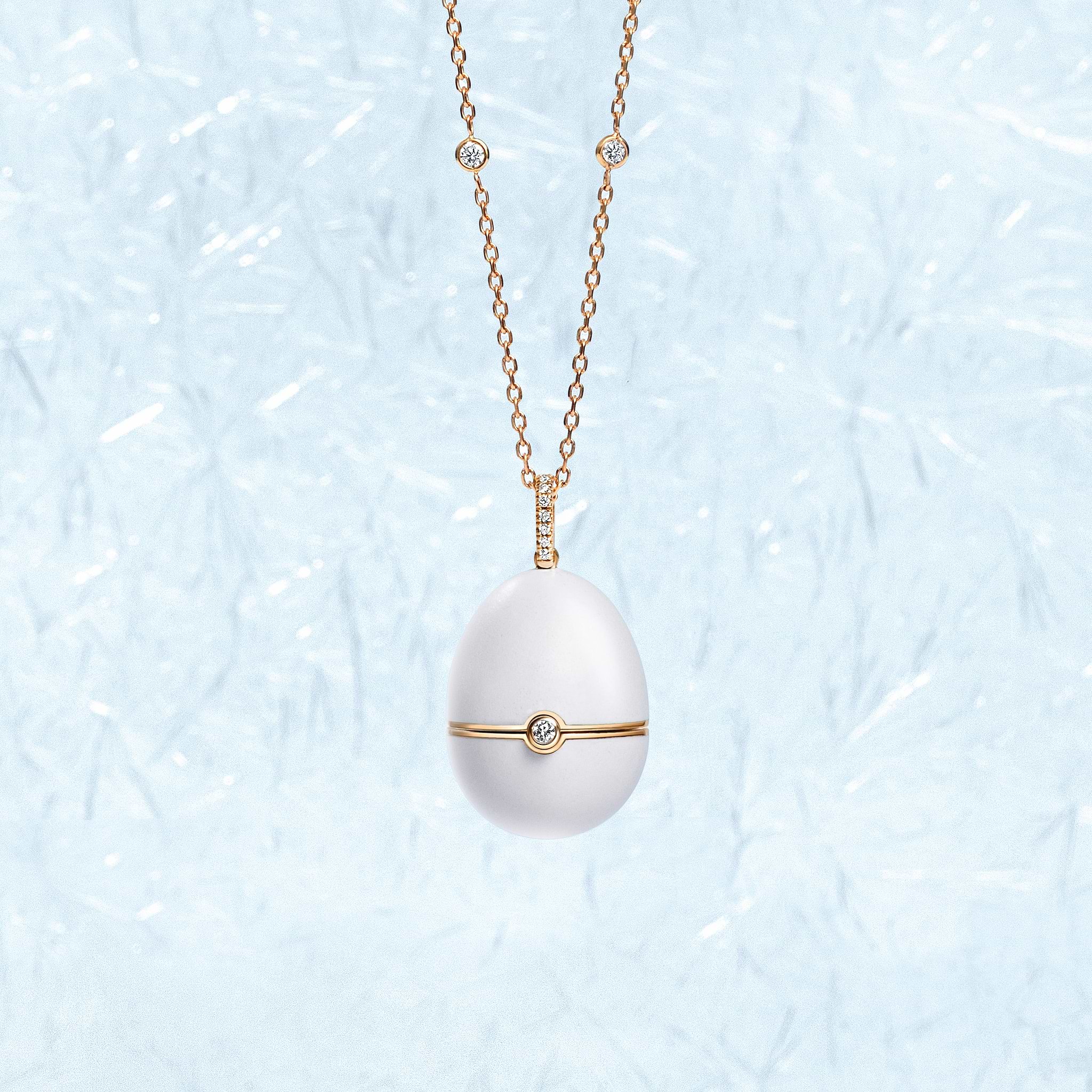 Fabergé white enamel pendant on a patterned light blue background