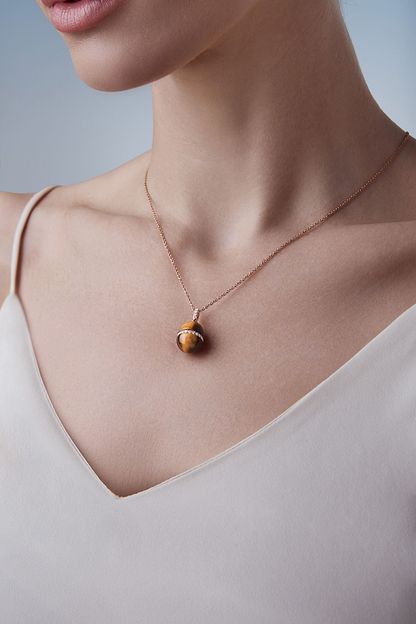 Female model wearing Fabergé Heritage Forever Tigers Eye Pendant in 18k rose gold with diamonds. 