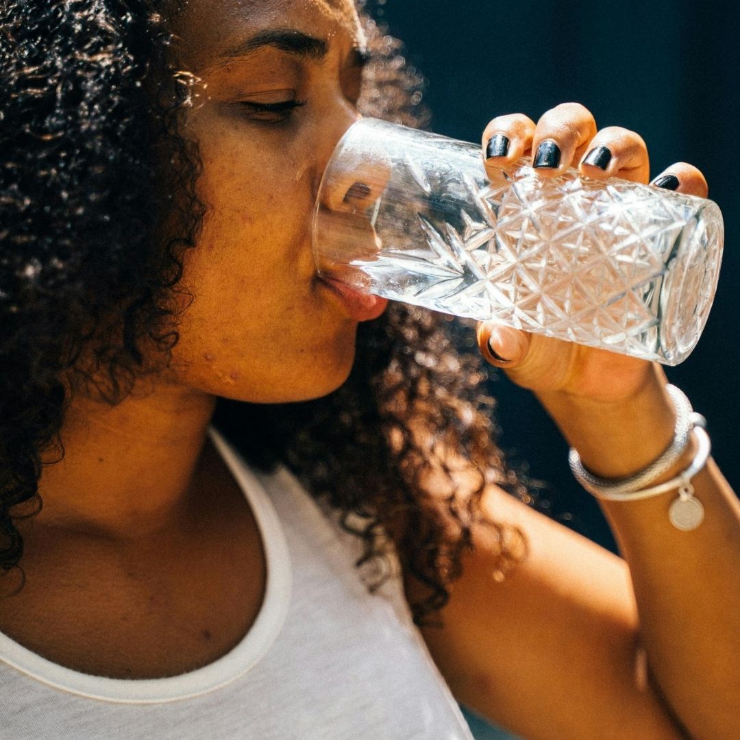 woman drinking water to stay hydrated