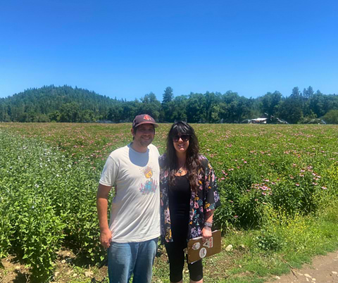 WishGarden's Sourcing Manager Lauren Nichols and Pacific Botanicals' Purchasing Manager Nate Brennan in a field of lemon balm and echinacea.