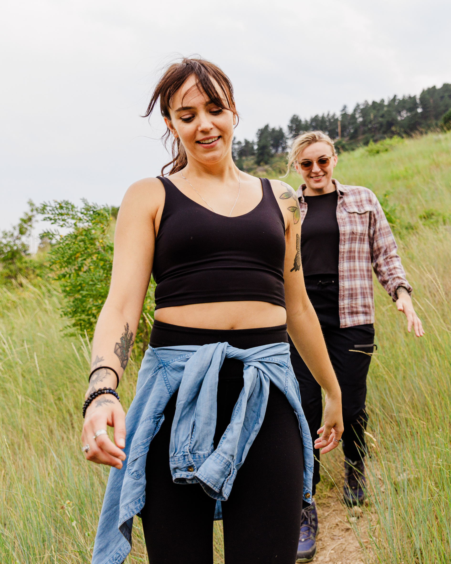 Two women walking on a trail in a natural setting