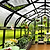 Greenhouse interior with plants, tables, and chairs