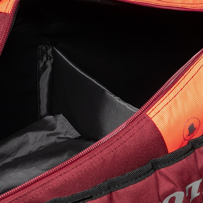 The Dunlop CX Performance 12 Badminton Racket Bag in black and red is designed with ergonomic shoulder straps for enhanced comfort. It features a roomy interior with a zippered compartment, text logo, and front pocket, making it ideal for storing rackets.