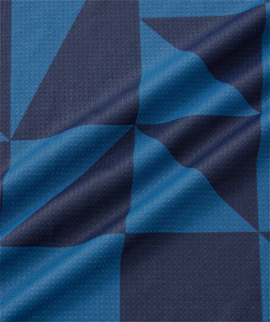 A close-up of indigo blue geometric-patterned fabric from the Yonex 10712YX Crew Neck Men's Badminton T-Shirt, featuring subtle texture and diagonal folds—ideal for quick-drying sportswear.