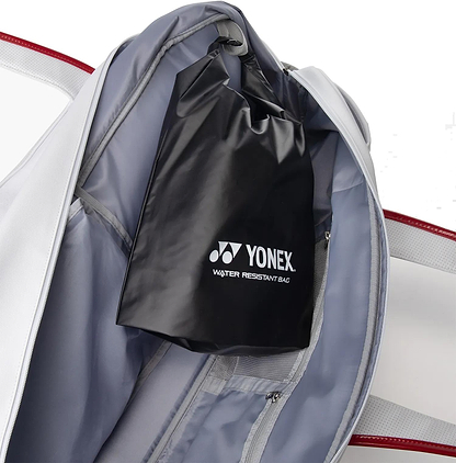 A Yonex 02631WEX Expert Tournament Badminton Bag - White, featuring the Yonex logo and "Water Resistant Bag" text, is shown inside a white and gray sports bag with red accents.