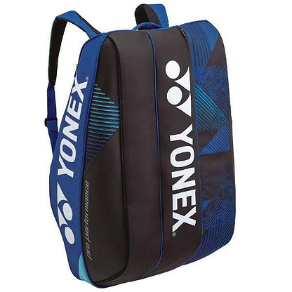 The Yonex 924212EX Pro 12 Racket Badminton Bag in cobalt blue features white branding along with padded shoulder straps, zipper compartments, and geometric patterns on the sides. It includes thermo-guard compartments and can hold up to 12 rackets for optimal storage.