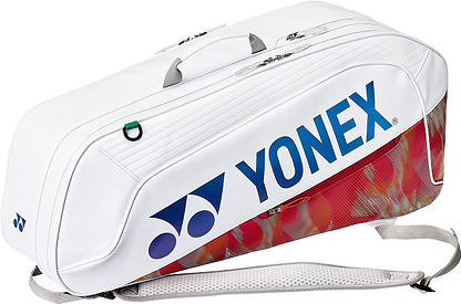 The Yonex 02626EX Expert 6 Racket Badminton Bag in white features a large blue Yonex logo, zippered compartments, top handle, shoulder strap, red and gray flame-like pattern on the lower part, and Thermo Guard protection for your gear.
