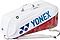 The Yonex 02626EX Expert 6 Racket Badminton Bag in white features a large blue Yonex logo, zippered compartments, top handle, shoulder strap, red and gray flame-like pattern on the lower part, and Thermo Guard protection for your gear.