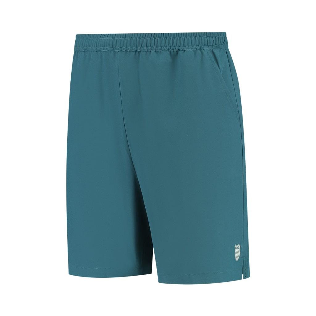 The K-Swiss Hypercourt Men's 7 Inch Badminton Shorts in Indian Teal feature an elastic waistband and a small white logo on the lower left side. They come equipped with deep side pockets and 4-way density stretch fabric, ensuring both convenience and freedom of movement.