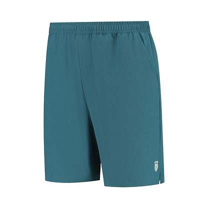 The K-Swiss Hypercourt Men's 7 Inch Badminton Shorts in Indian Teal feature an elastic waistband and a small white logo on the lower left side. They come equipped with deep side pockets and 4-way density stretch fabric, ensuring both convenience and freedom of movement.