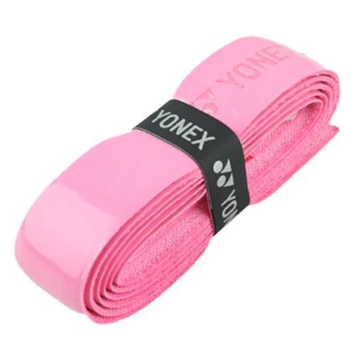 The Yonex AC420 Hi Soft Badminton Overgrip in pink, featuring a glossy texture and neatly coiled design, secured with a black band bearing the "Yonex" label, provides exceptional comfort for players.