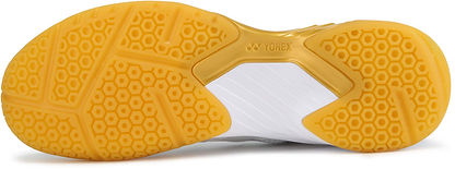 Close-up of the yellow and white sole on Yonex Power Cushion SHB 101 Badminton Shoes - White / Gold, showing a hexagonal tread for grip and advanced shock absorption.
