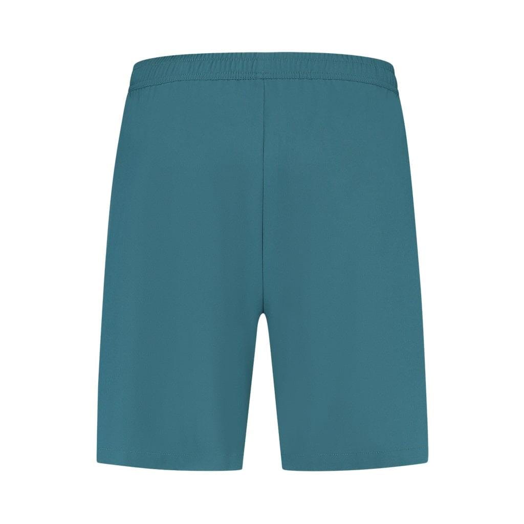 A pair of Indian Teal K-Swiss Hypercourt Men's 7 Inch Badminton Shorts is centered on a white background. The shorts feature a 4-way density stretch for optimal comfort and flexibility, while maintaining a simple design with an elastic waistband and no visible pockets or additional details.