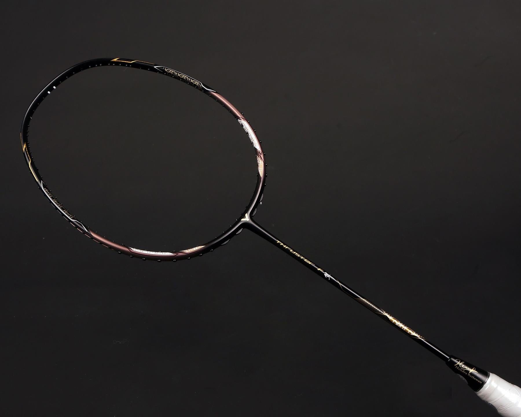 Featuring a sophisticated design in black with metallic gold details, the Victor Thruster FC Hendra Setiawan LTD Edition 3U Badminton Racket reflects Hendra Setiawan's signature style against a dark backdrop.