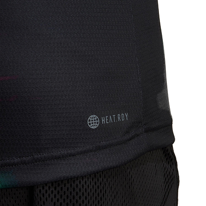 Close-up of an eco-friendly black athletic shirt, labeled with "HEAT.RDY" and a globe icon, crafted using sustainable carbon recycling. The adidas Melbourne Men's Freelift Polo Shirt features a textured, breathable design, perfectly paired with black mesh shorts.