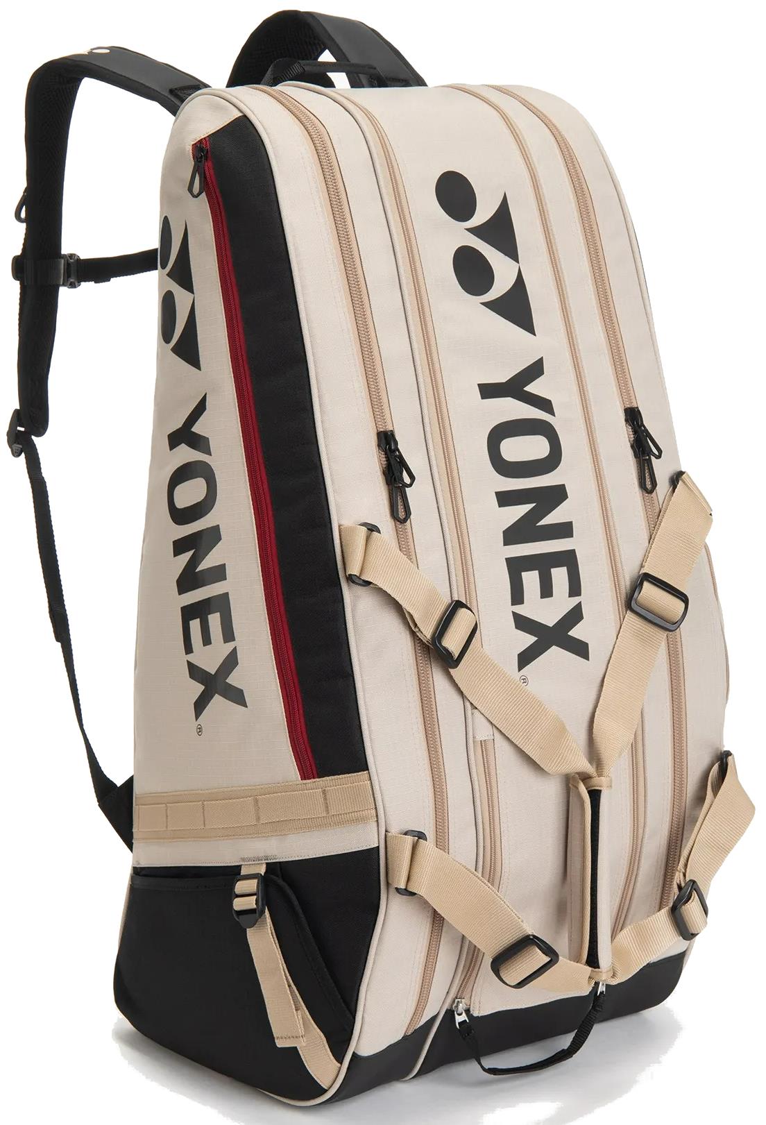 The Yonex BA72629EX Gearlogic 9 Racket Badminton Bag in beige features black accents, bold Yonex logos, multiple zip compartments, and adjustable straps—ideal for stylishly carrying all your badminton gear.