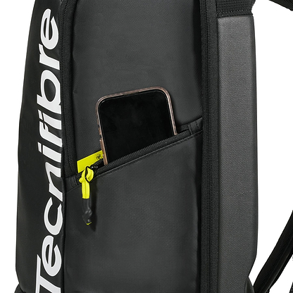 The Tecnifibre Reform Badminton Backpack - Black features a side zippered pocket with a smartphone partially visible and showcases the white vertical Tecnifibre logo on its EVA material.