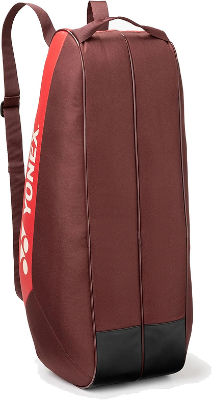 The Yonex 42526EX Team 6 Racket Badminton Bag in Ruby Red features a white Yonex logo, shoulder strap, top handle, and reinforced black base. Holds up to 6 rackets for convenience and durability.