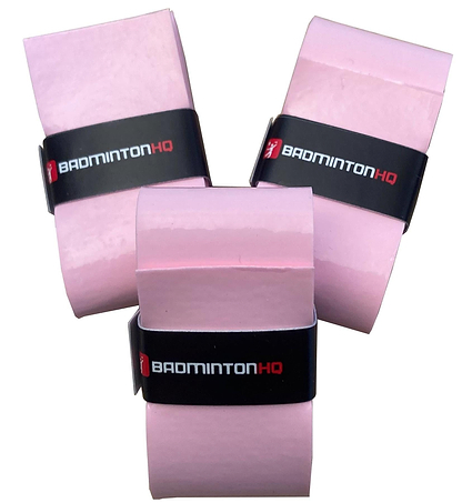 The BadmintonHQ 3 Pack Badminton Overgrips in pink, designed for sweat-absorption and enhanced control, are stacked together with each grip secured by a black "BadmintonHQ" band on a clean white background.