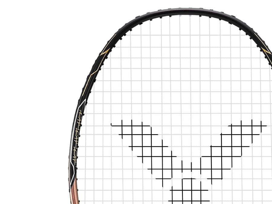 Close-up of the Victor Thruster FC Hendra Setiawan LTD Edition 3U badminton racket's head, highlighting its geometric string pattern. The black frame features decorative gold elements on the side, epitomizing an advanced-level racket. The background is a plain white canvas.