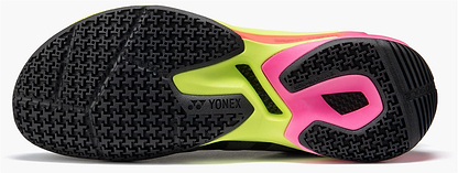 Close-up of the Yonex Subaxia GT Mens Badminton Shoes sole in dark grey, highlighting a black textured grip with neon yellow and pink accents. The Yonex logo appears near the center, featuring advanced GRPHT THRTTL technology for top performance.