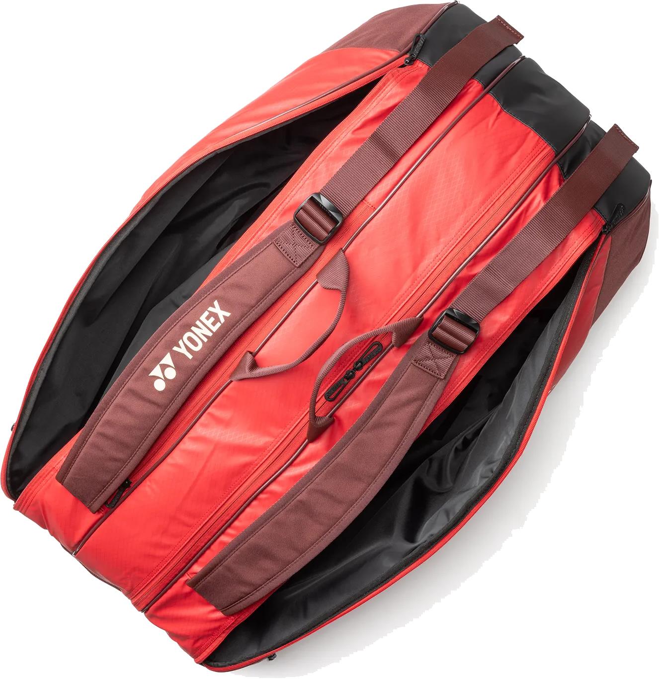 The Yonex 42529EX Team 9 Racket Badminton Bag in Ruby Red features brown straps and roomy black-lined compartments, perfect for rackets and gear—just like top Yonex badminton bags.