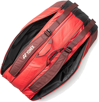 The Yonex 42529EX Team 9 Racket Badminton Bag in Ruby Red features brown straps and roomy black-lined compartments, perfect for rackets and gear—just like top Yonex badminton bags.
