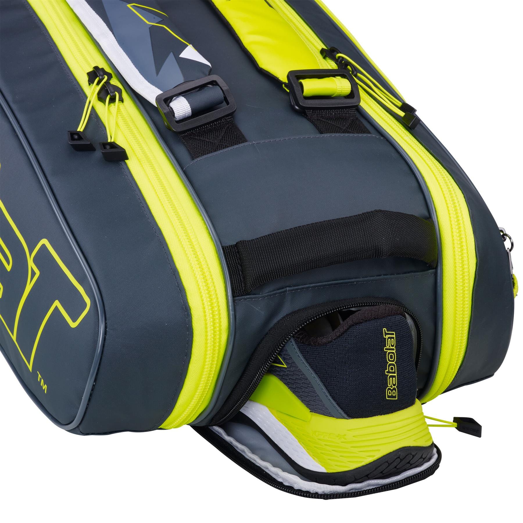 The Babolat RHX6 Pure Aero Racket Bag in grey and yellow showcases a waterproof and durable design. A partially open shoe compartment reveals a Babolat tennis shoe, with the bag's sleek style highlighted by a vibrant yellow zipper and prominent branding from Babolat.