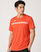 A man stands against a plain light background, wearing the Yonex 10711YX Crew Neck Mens Badminton T-Shirt in Cyber Orange, featuring subtle horizontal stripes and a small white Yonex logo on the left chest.