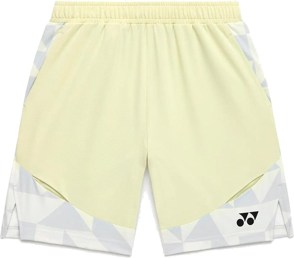 The Yonex 15240YX Knit Men's Badminton Shorts in Champagne feature a light yellow color with white and gray geometric accents, breathable fabric, elastic waistband, side pockets, and a small black Yonex logo on the lower left leg.