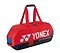 The Yonex 92431WEX Pro Tournament 6 Racket Badminton Bag in Scarlet is equipped with dual handles and a zippered top featuring durable YKK zippers. The bag prominently displays the Yonex logo along with "pro performance" text in white, complemented by sleek black and blue accents on the sides.