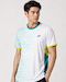 A man with short dark hair wears the Yonex YTM11 Mens Badminton T-Shirt - White by Yonex, which has light green geometric patterns, teal and yellow accents, Air-Release fabric, and a small chest logo, standing against a plain light background.