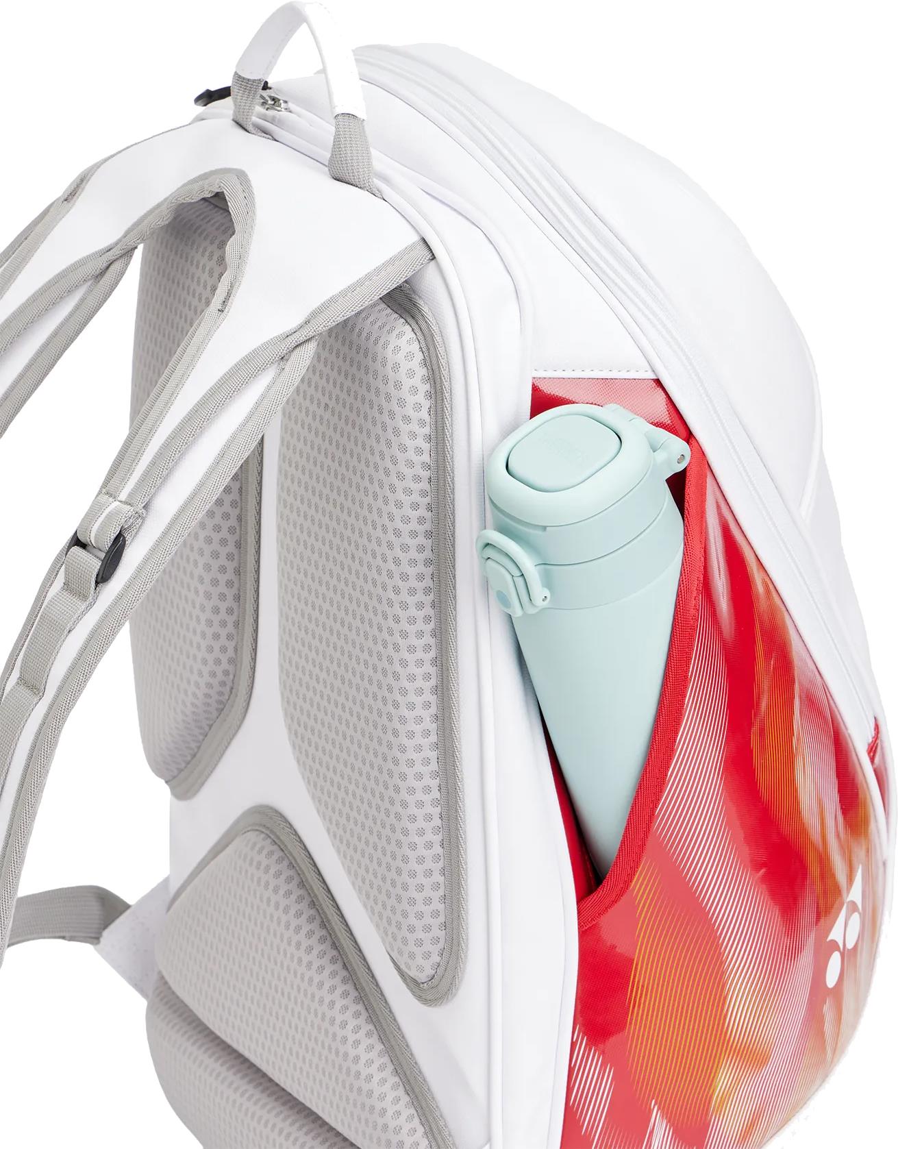 The Yonex 02612EX Expert Badminton Backpack in white features padded gray straps, a red side pocket with a blue reusable bottle, and is ideal as a racket bag or everyday backpack for active lifestyles.